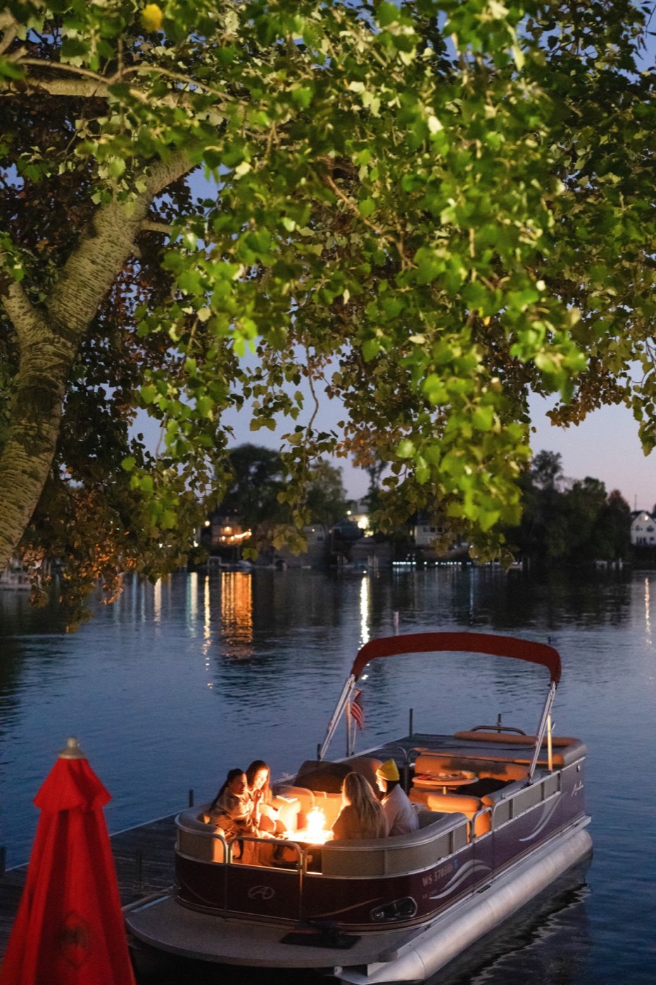 A lit boat on the water at dusk, photographed for a brand
