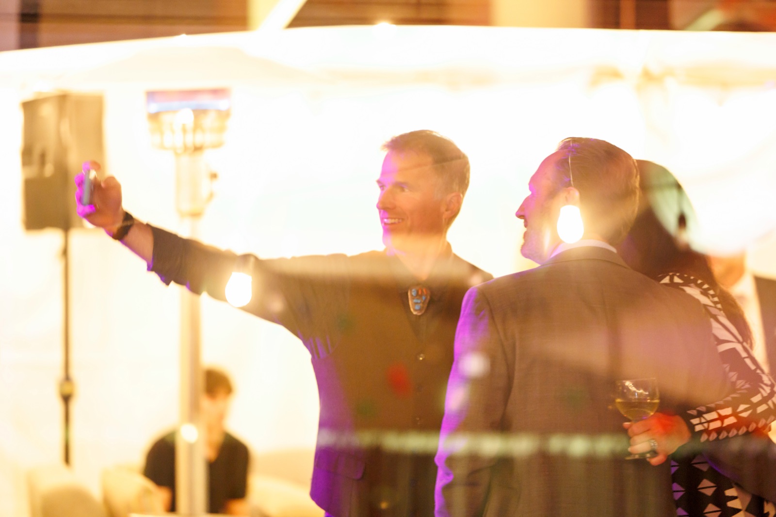 Two guests in warm light at an evening event