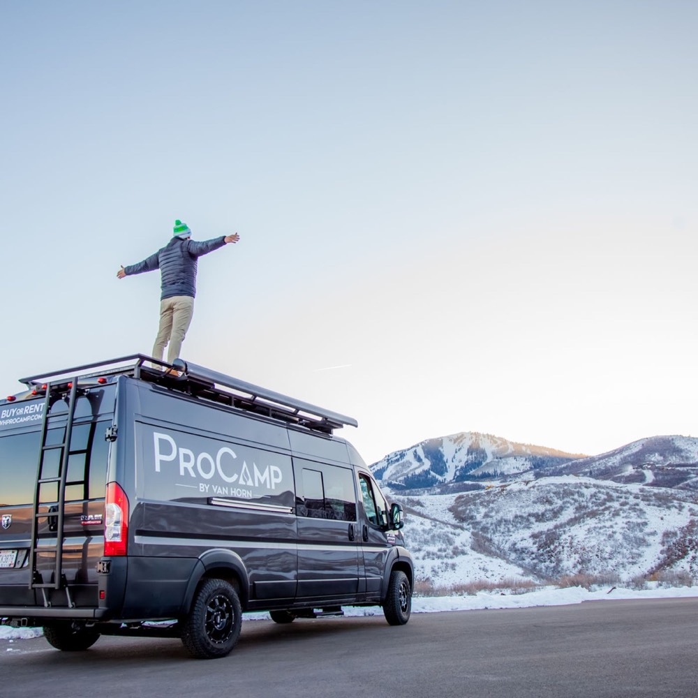A production van below snowy mountains