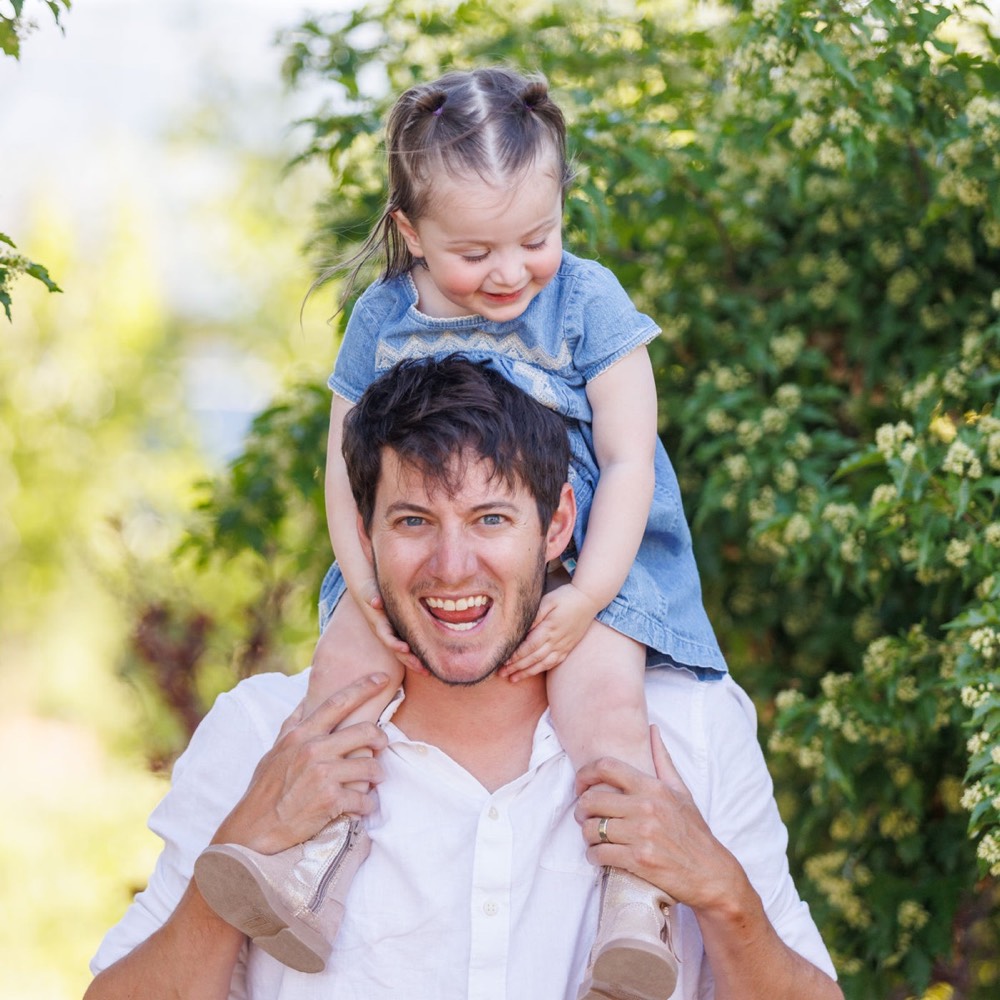A dad carrying his toddler on his shoulders