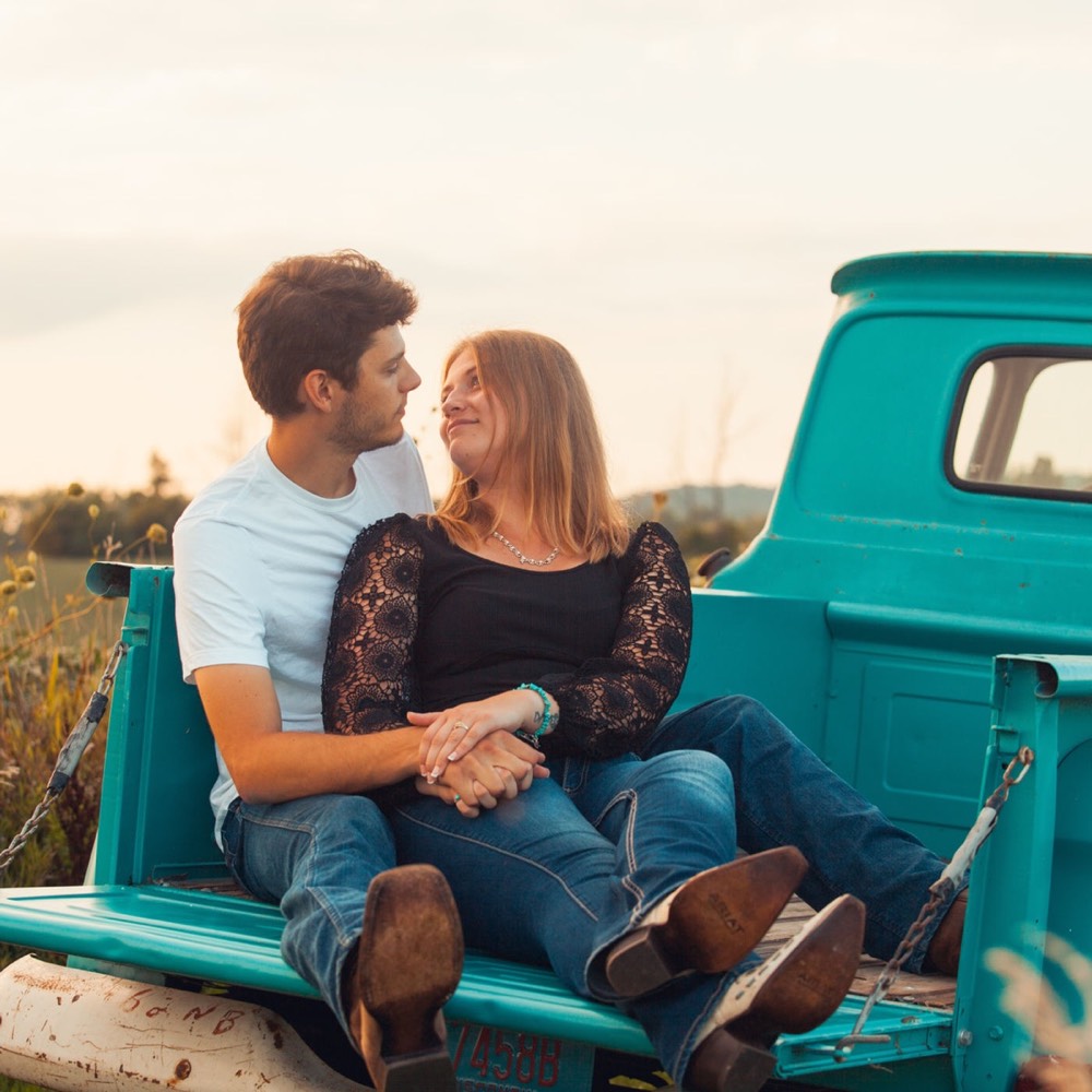 A family on a truck tailgate in a field