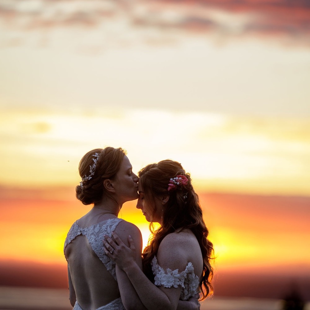 A couple kissing at sunset on their wedding day