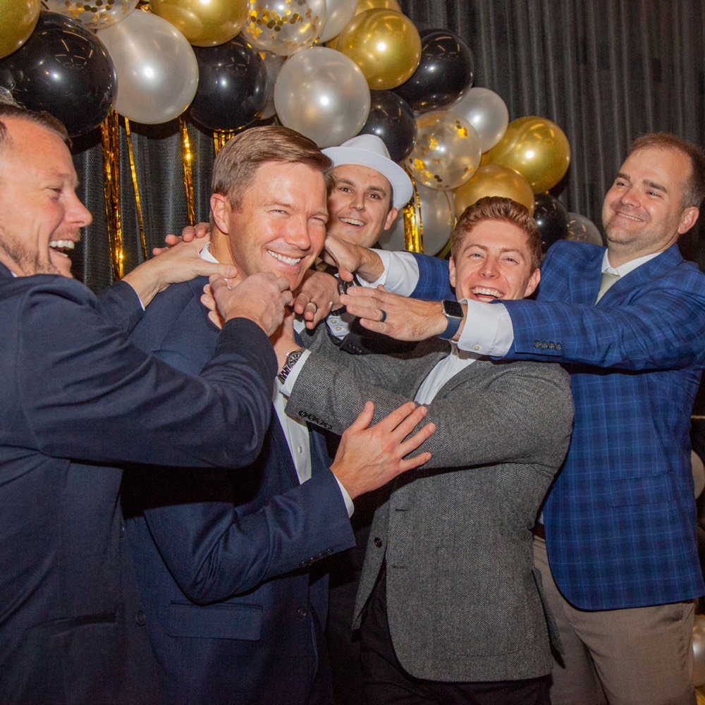 Guests laughing among gold balloons